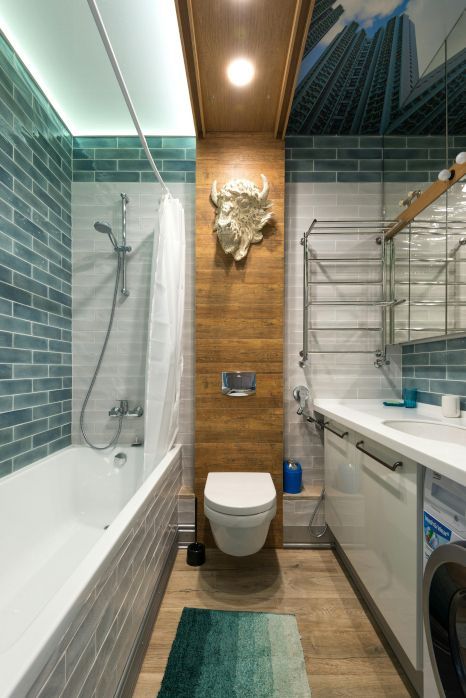 A bathroom with a toilet , sink , bathtub and shower. Professionally tiled by Orchid Tiling in Newport, Wales.