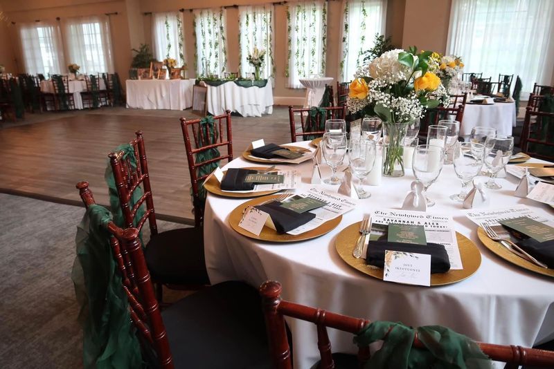 Elegant wedding reception with round tables, gold chargers, and floral centerpieces.