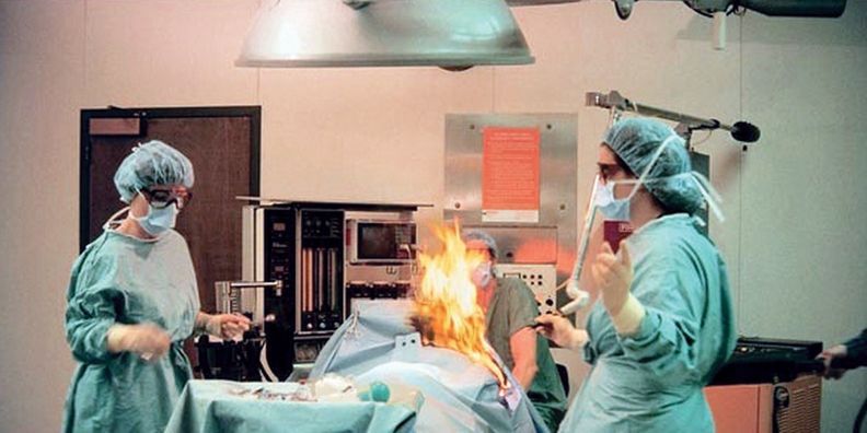 a group of surgeons are operating on a patient in an operating room .