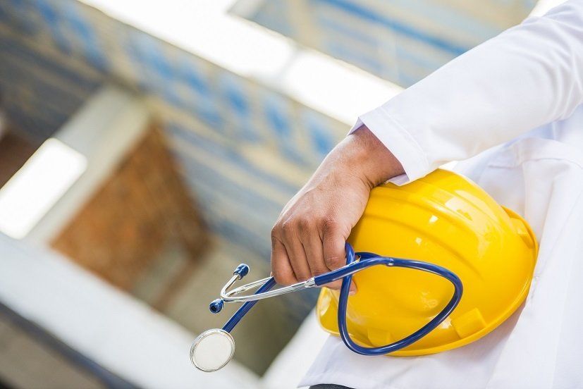 a person holding a hard hat and a stethoscope