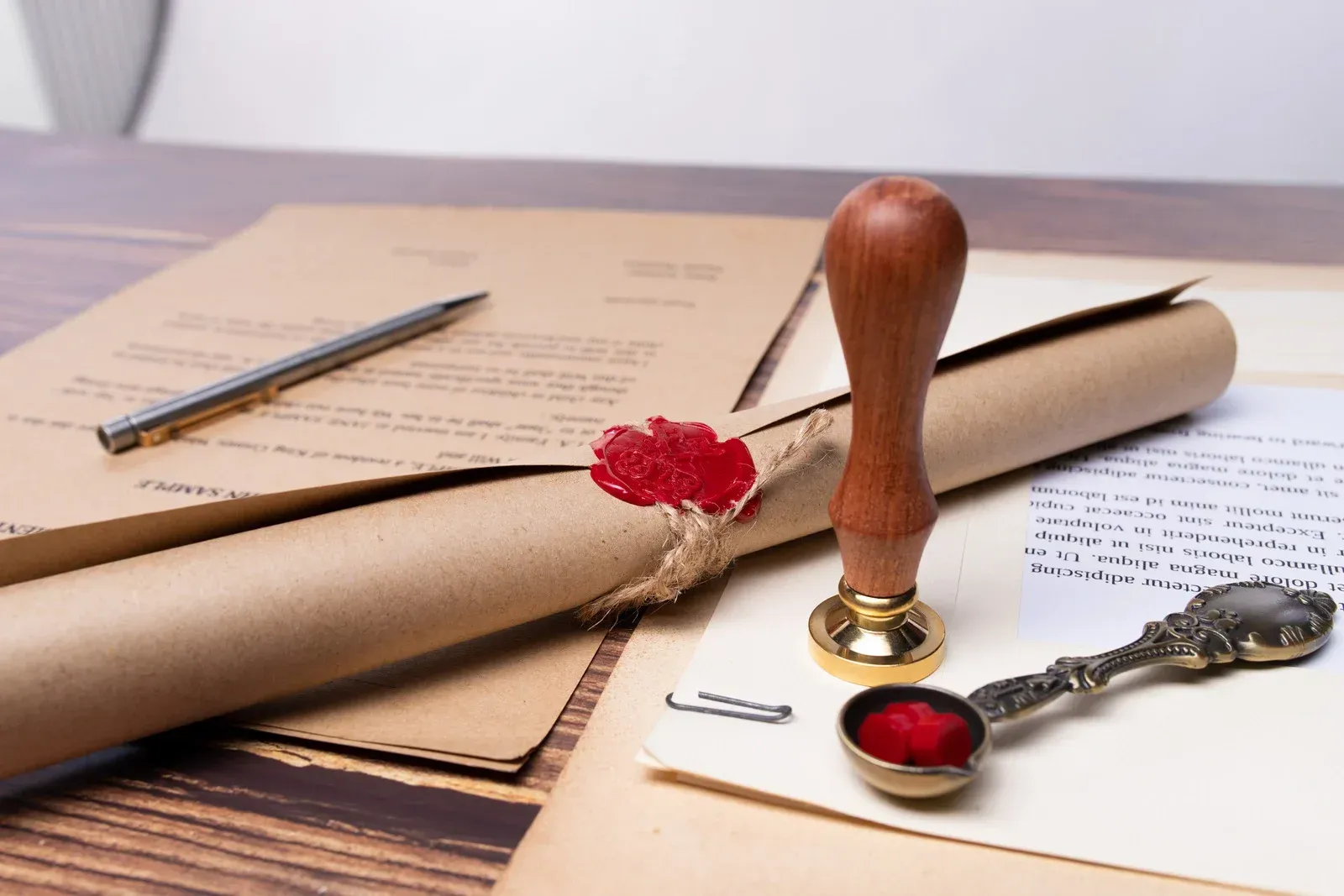 A seal and a pen are on a piece of paper on a table.
