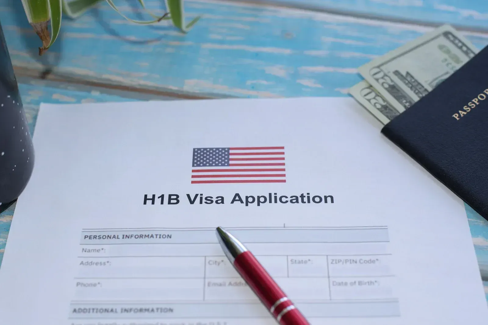 A pen is sitting on top of a h1b visa application.