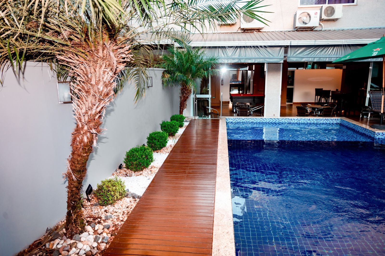 Uma grande piscina com uma passarela de madeira que leva até ela.