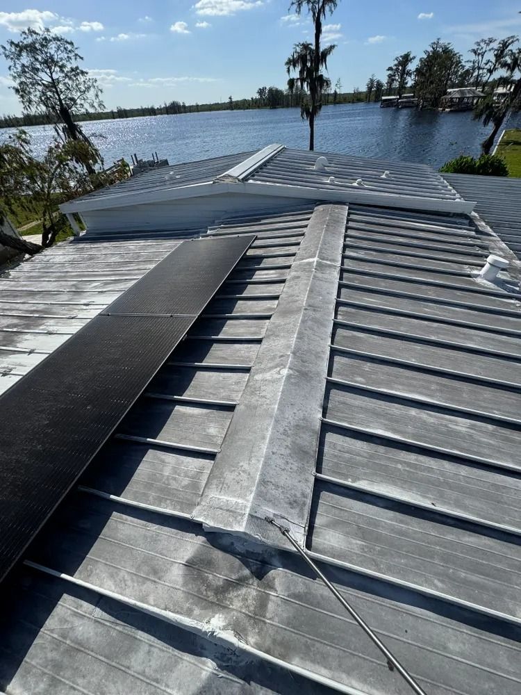 A close up of a roof with a lake in the background.