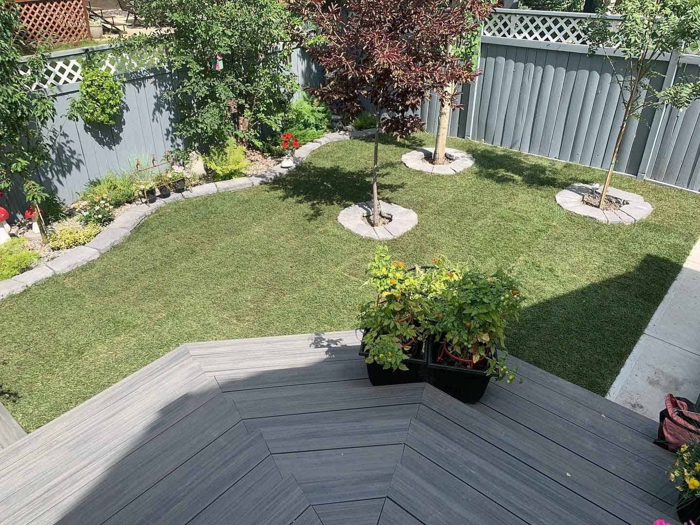 An aerial view of a backyard with a wooden deck and a fence.