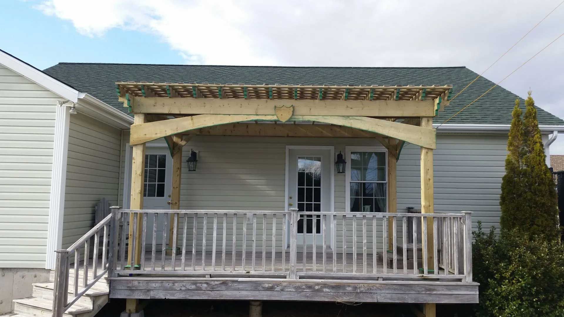 A house with a wooden porch and a green roof