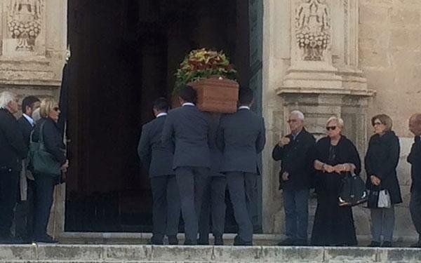 necrofori che trasportano un cofano funebre in chiesa