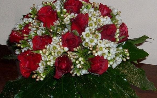 composizione floreale con rose rosse e fiorellini bianchi