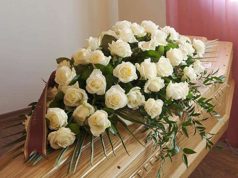 cuscino di fiori adagiato su una cassa funebre