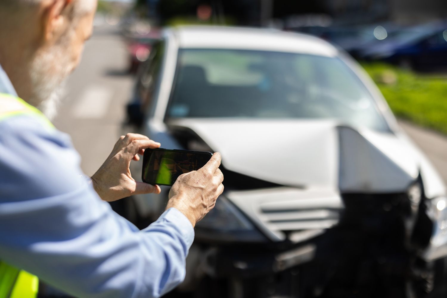 Man inspecting and photographing a crashed car. Man inspecting and photographing a crashed car.