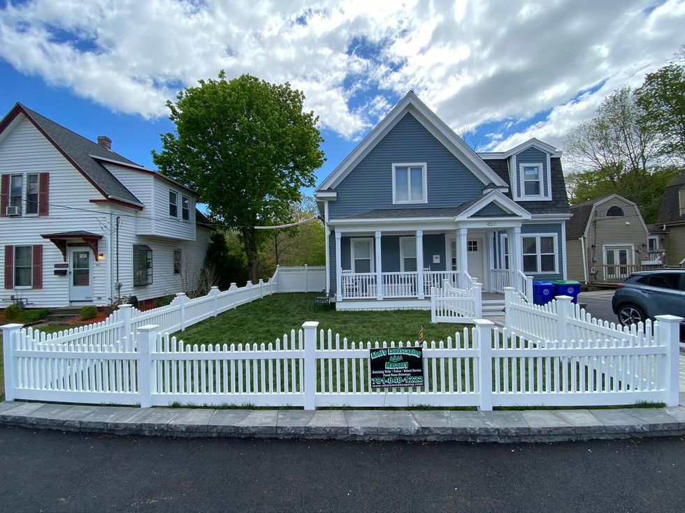 A house with a white picket fence in front of it