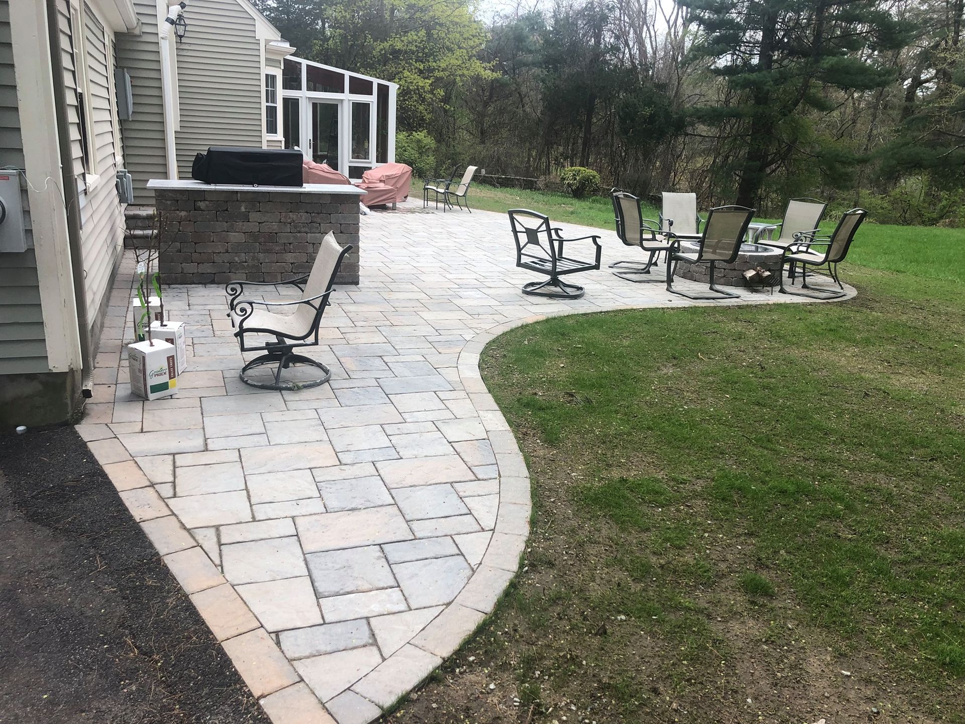A custom paved patio with chairs and tables in front of a house