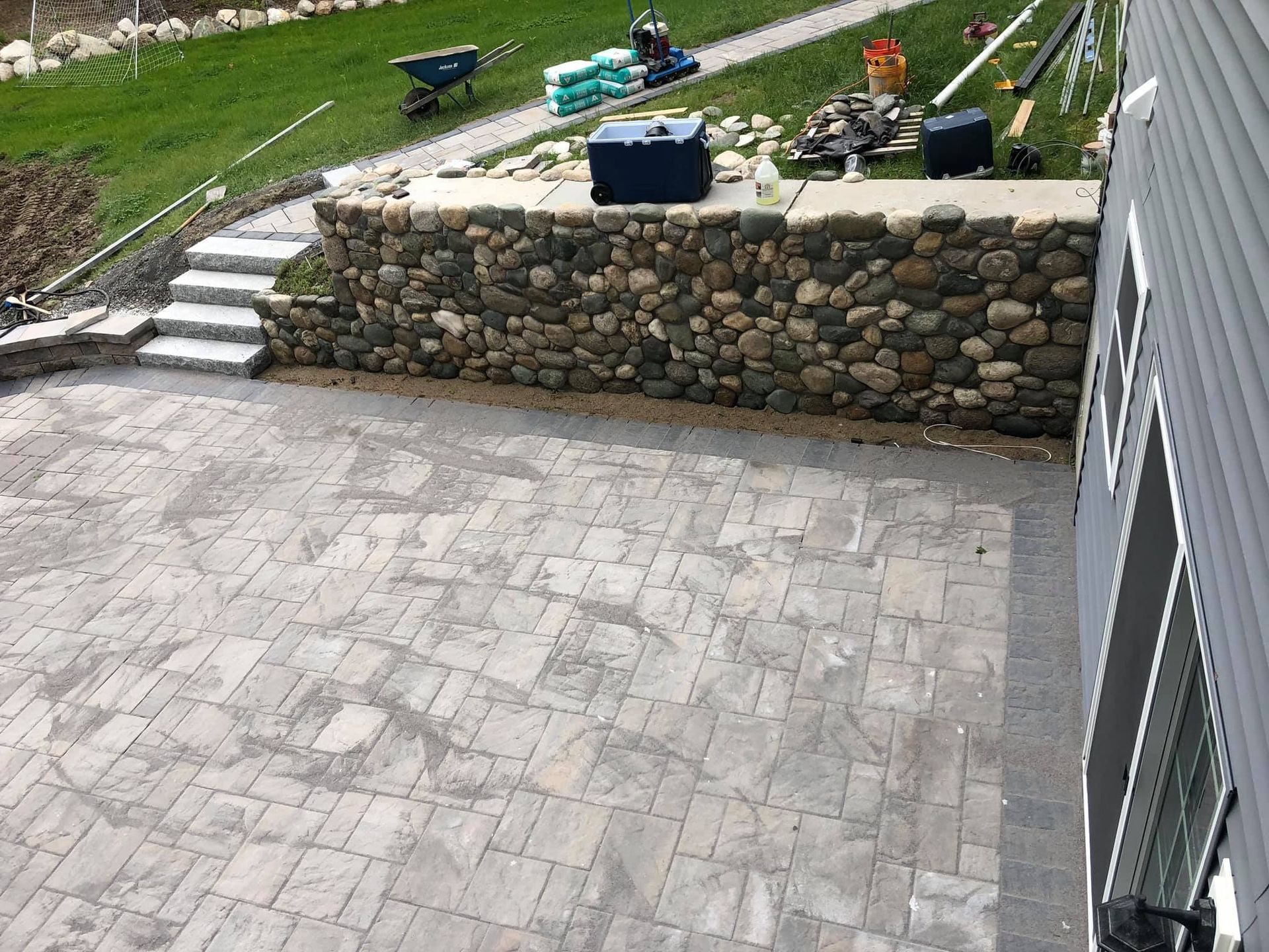 An aerial view of a patio with a stone wall in the background.