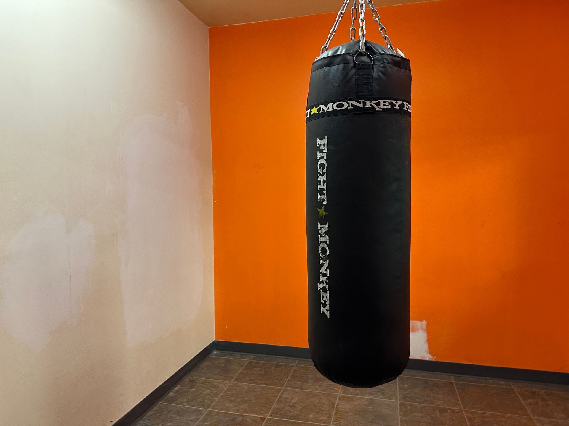 A boxing bag is hanging from the ceiling in a room
