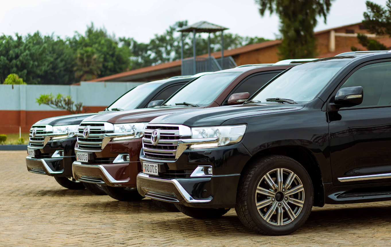 A row of toyota land cruisers are parked in a parking lot.