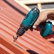 Person Using Drill On Roof - Clifton, TX - Bosque Supply Company