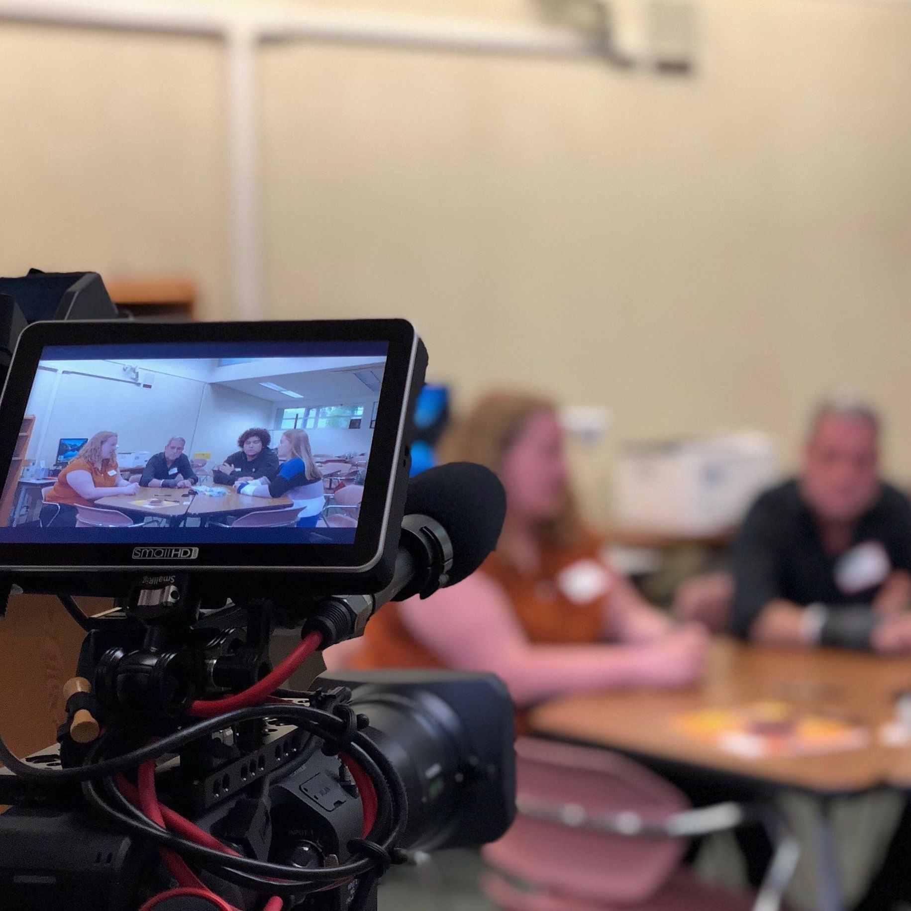 A video camera shows a group of people sitting at tables