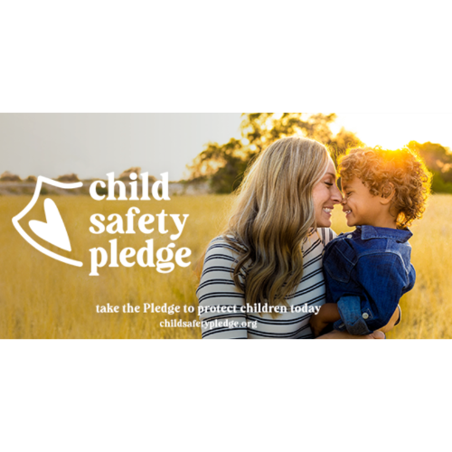 A woman is holding a child in her arms in a field.