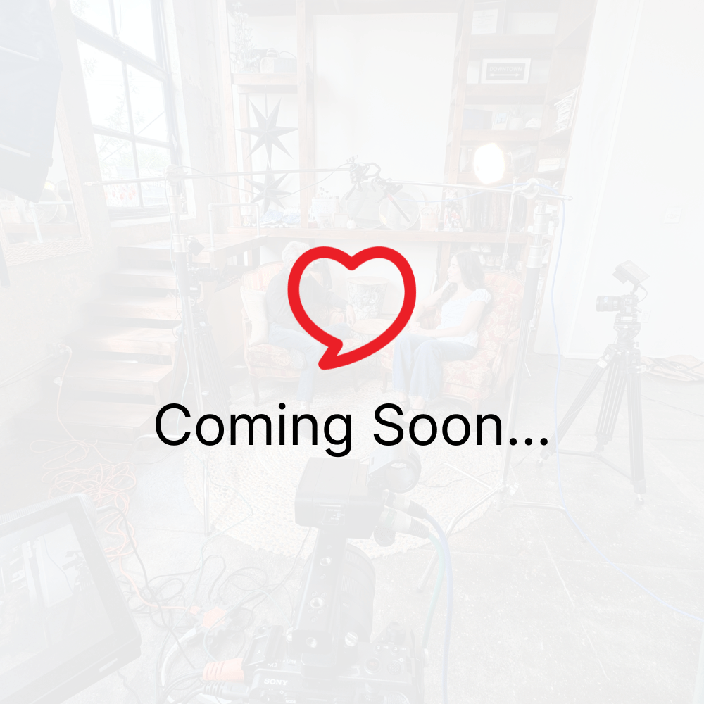 Red heart icon above “Coming Soon...” text on a faded café-style background.
