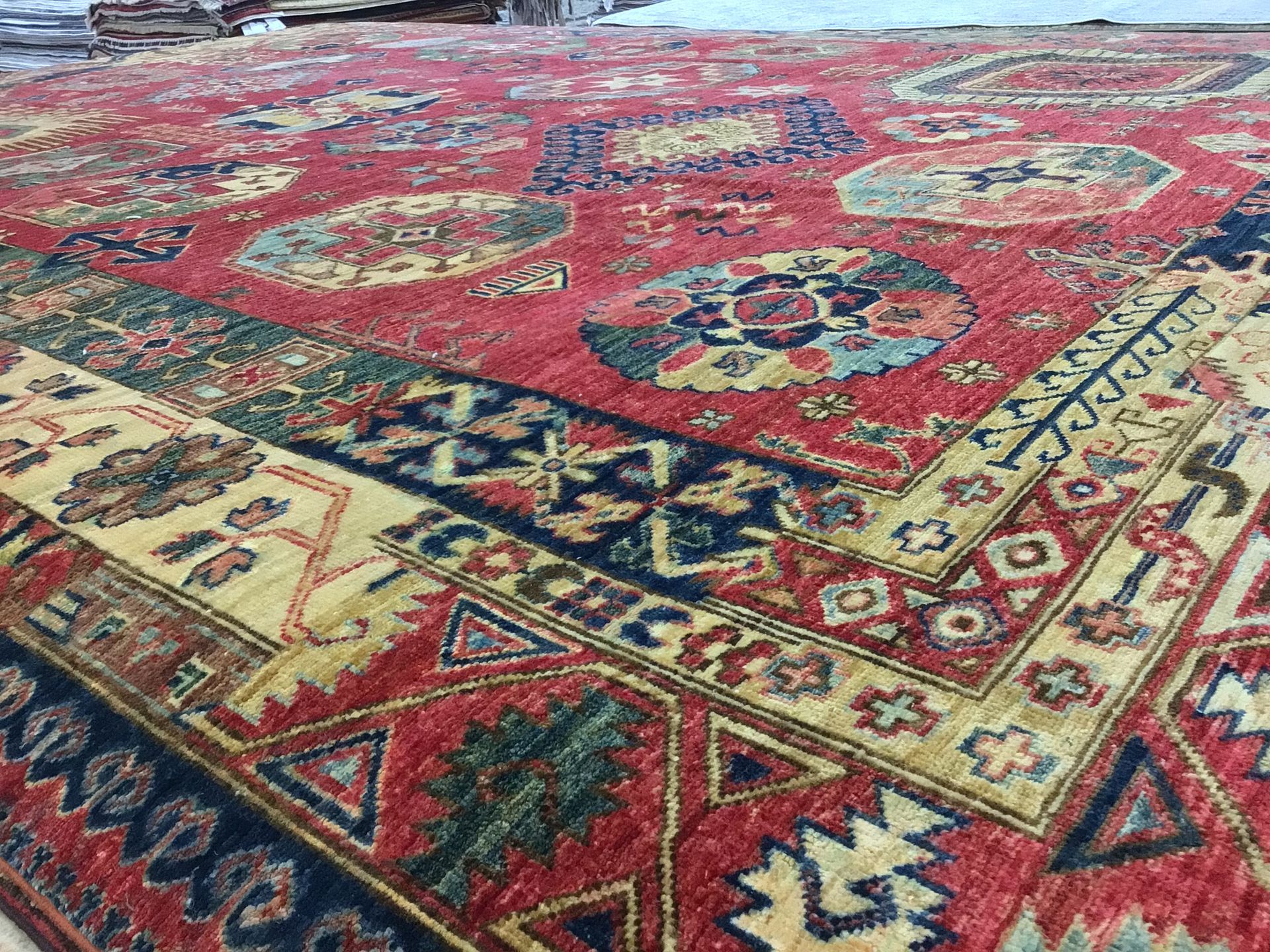 A close up of a red and yellow rug on a table.