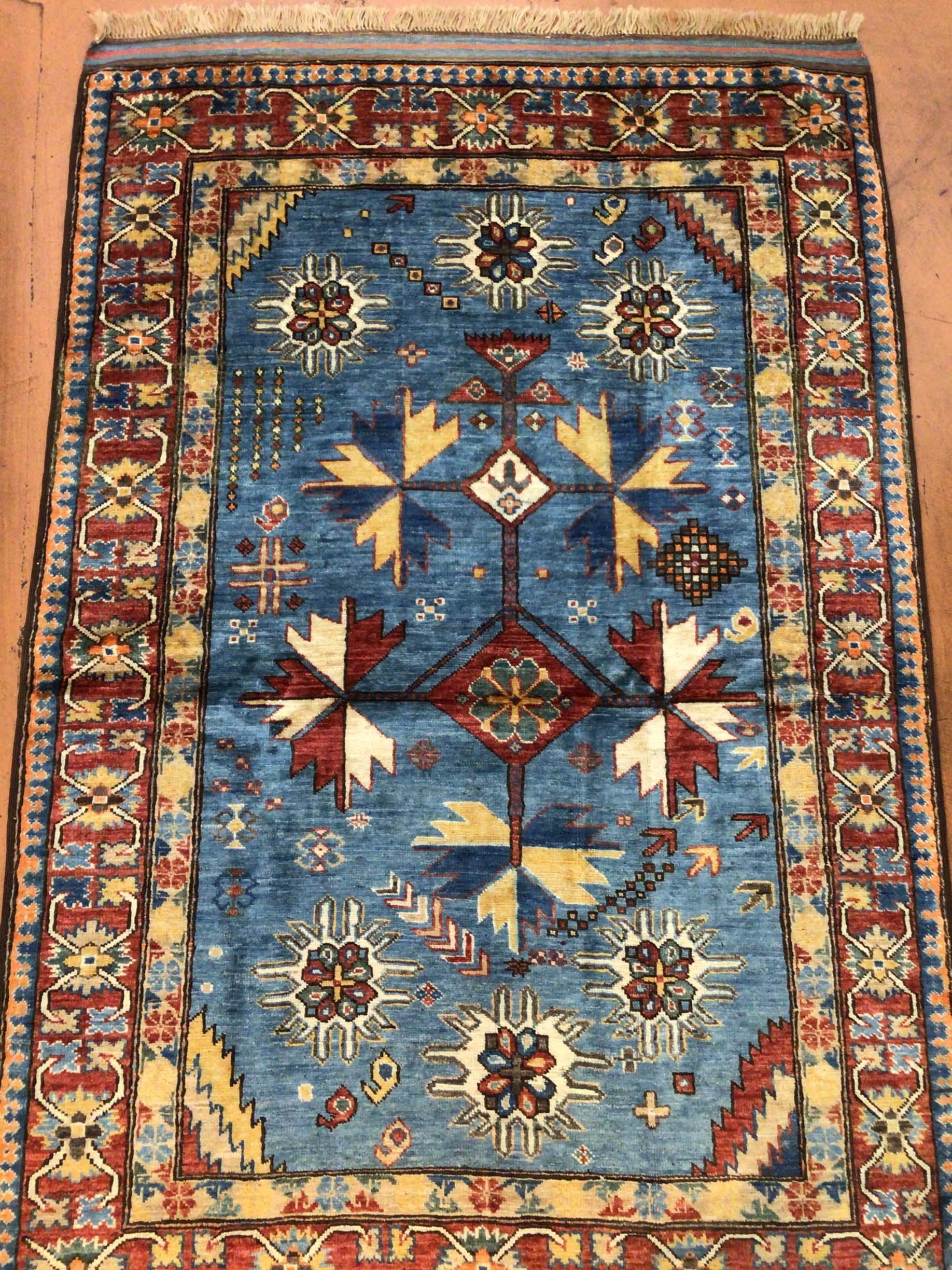A blue rug with a floral pattern is sitting on a wooden floor.