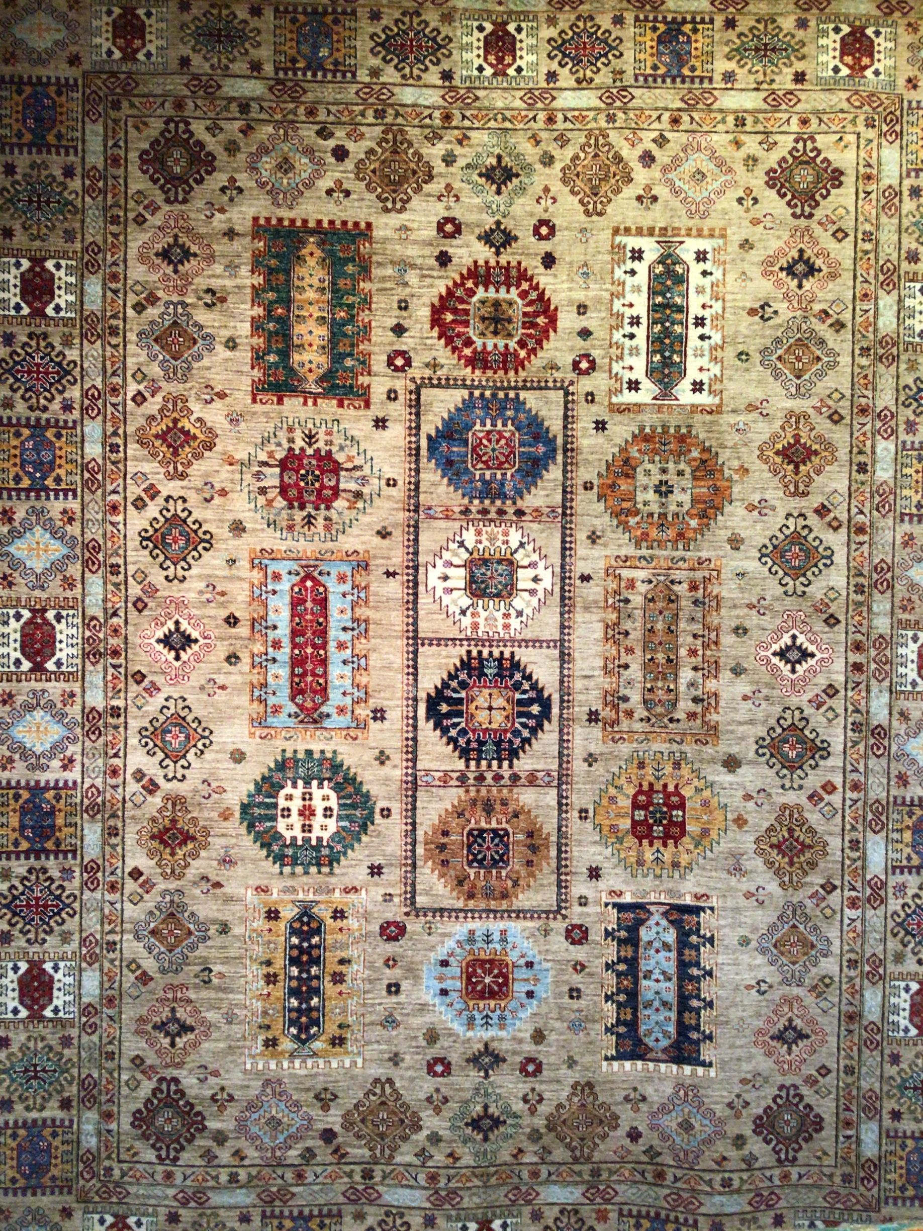 A rug with a pattern on it is hanging on a wall.