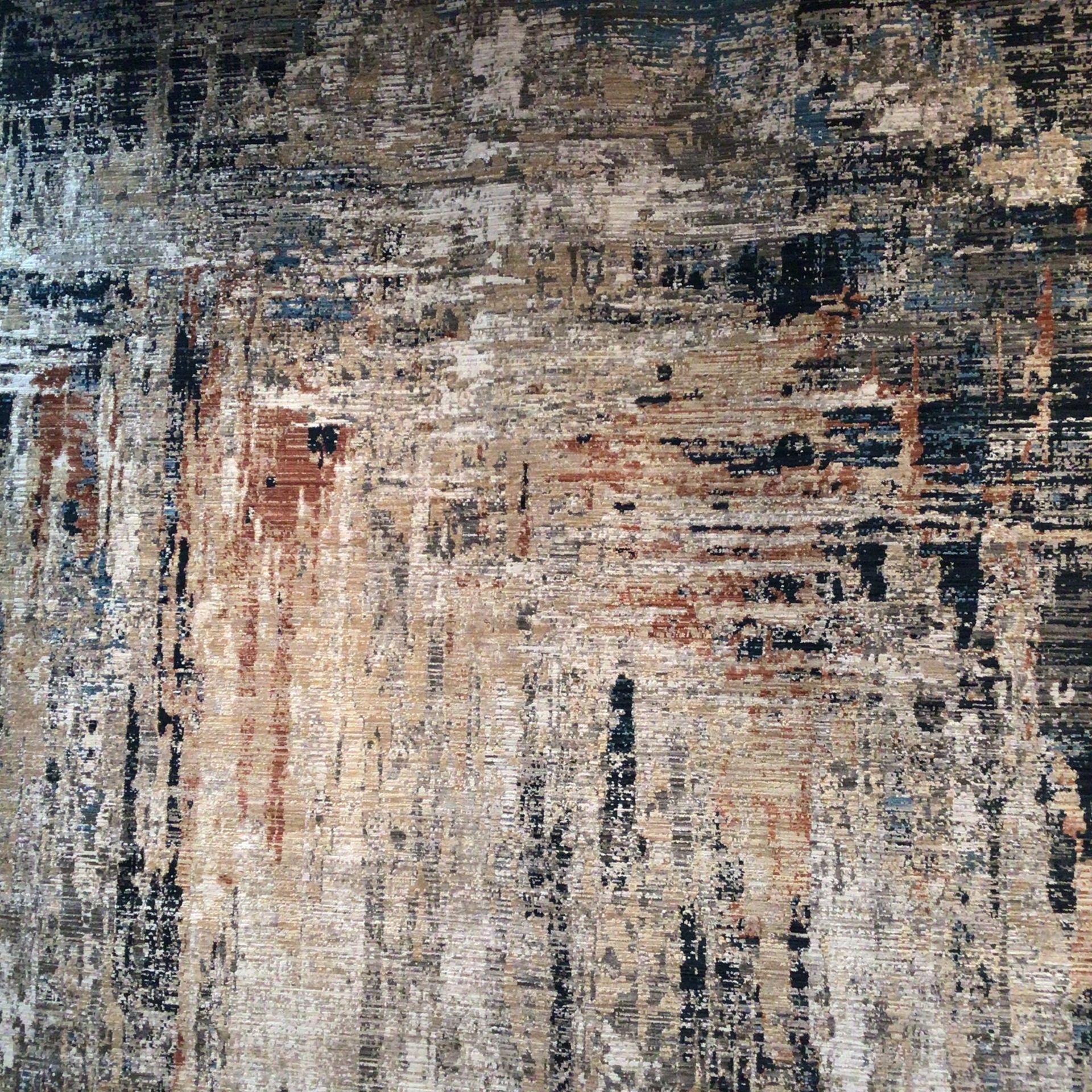 A close up of a rug with a brick wall in the background.