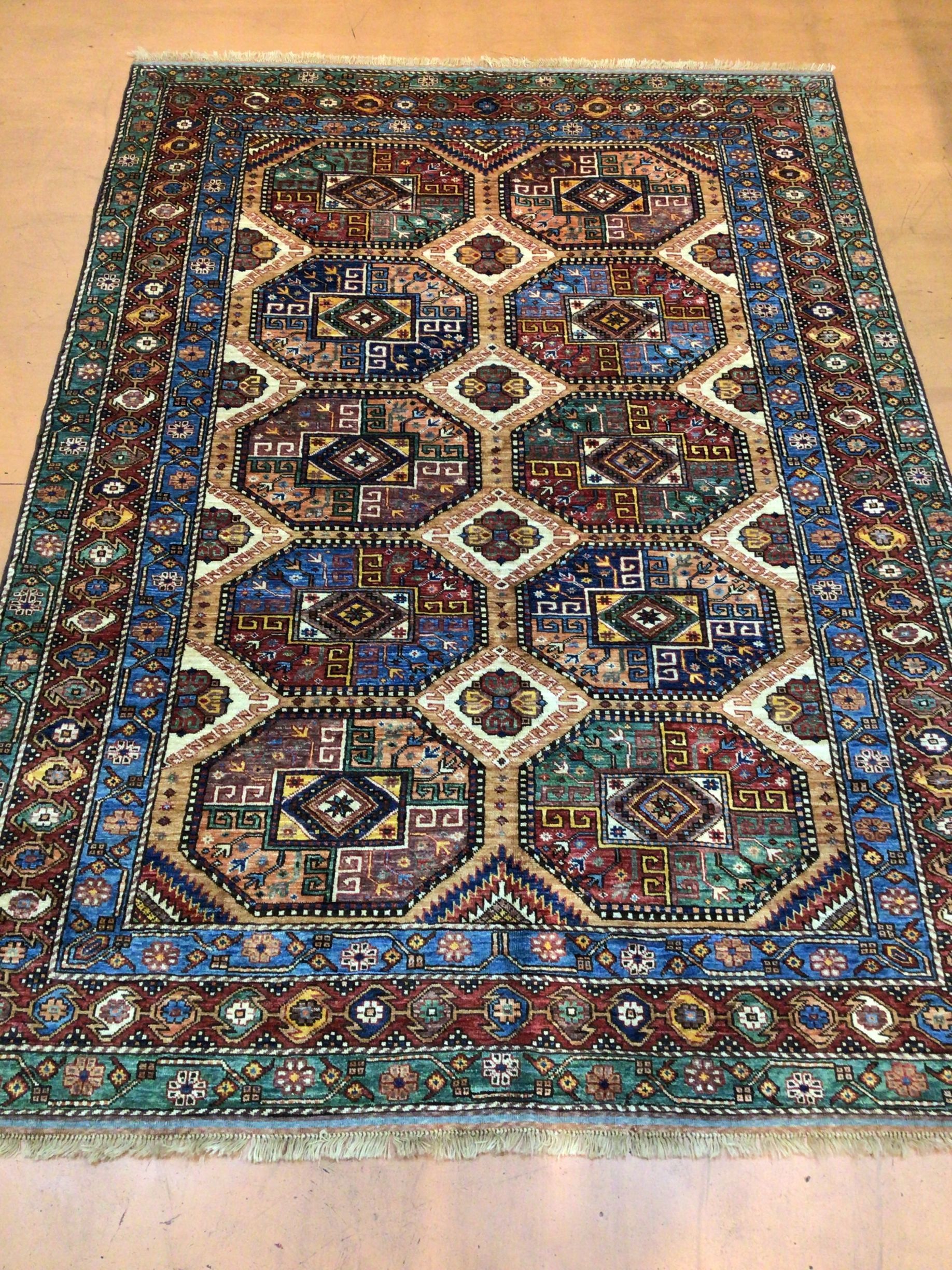 A colorful rug is sitting on a wooden floor.