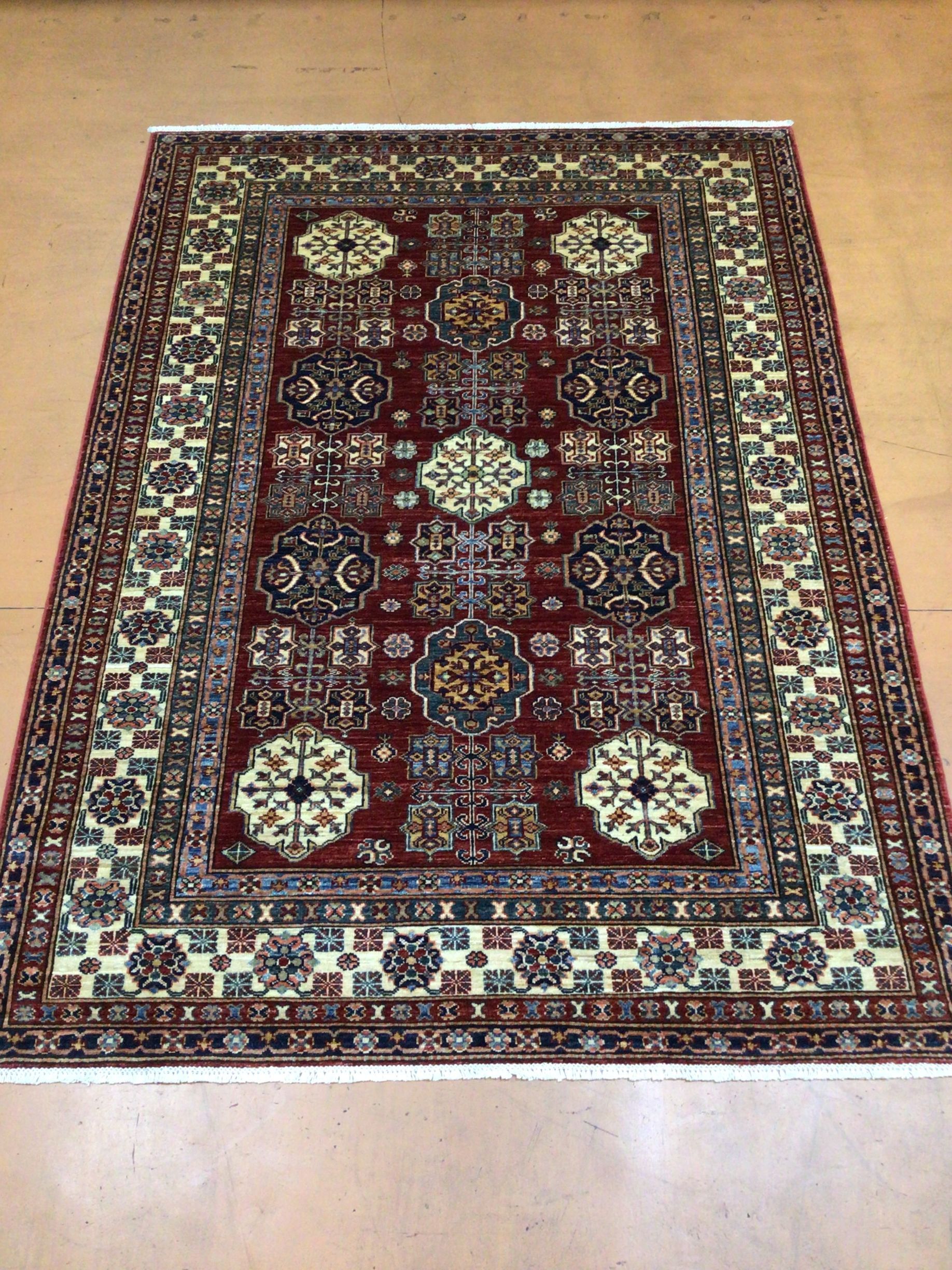 A red rug is sitting on a wooden floor.