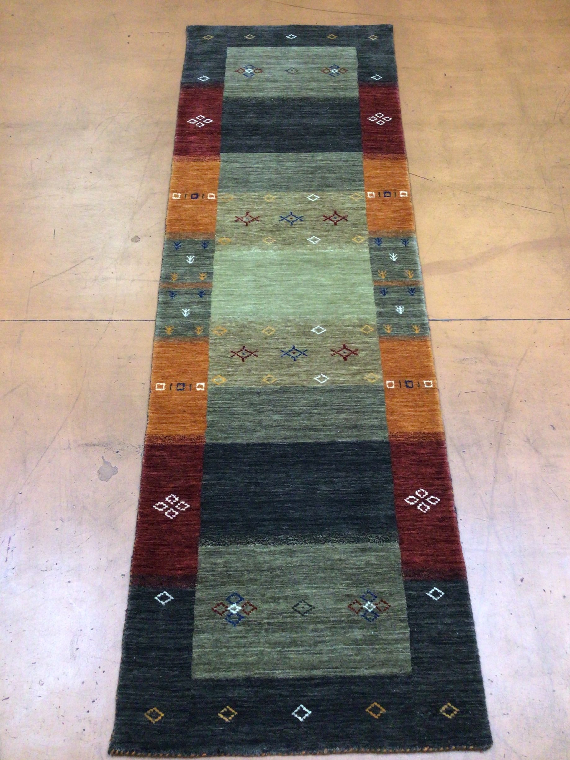 A colorful rug is sitting on a wooden floor.