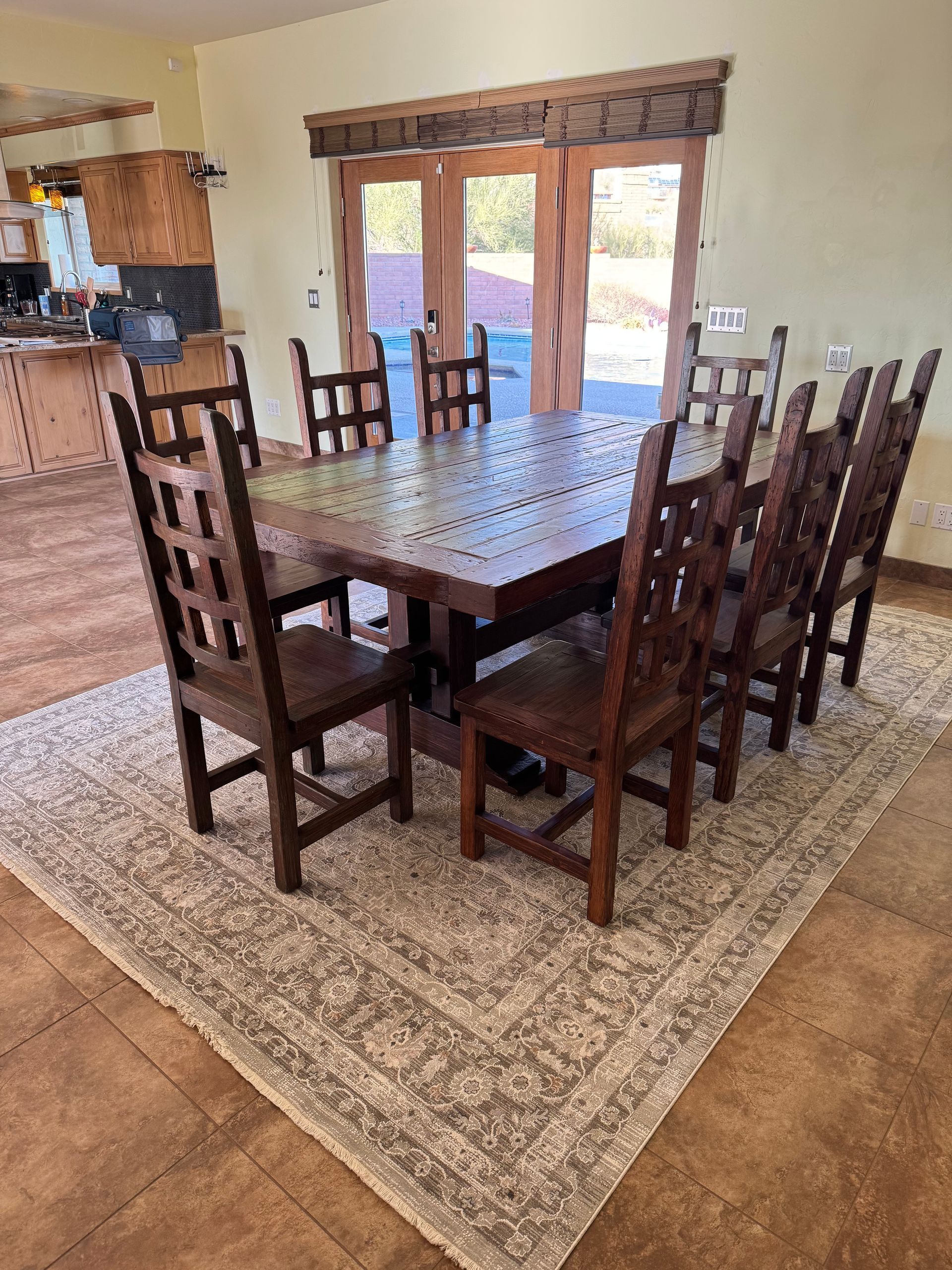 A dining room table and chairs are sitting on a rug in a room.