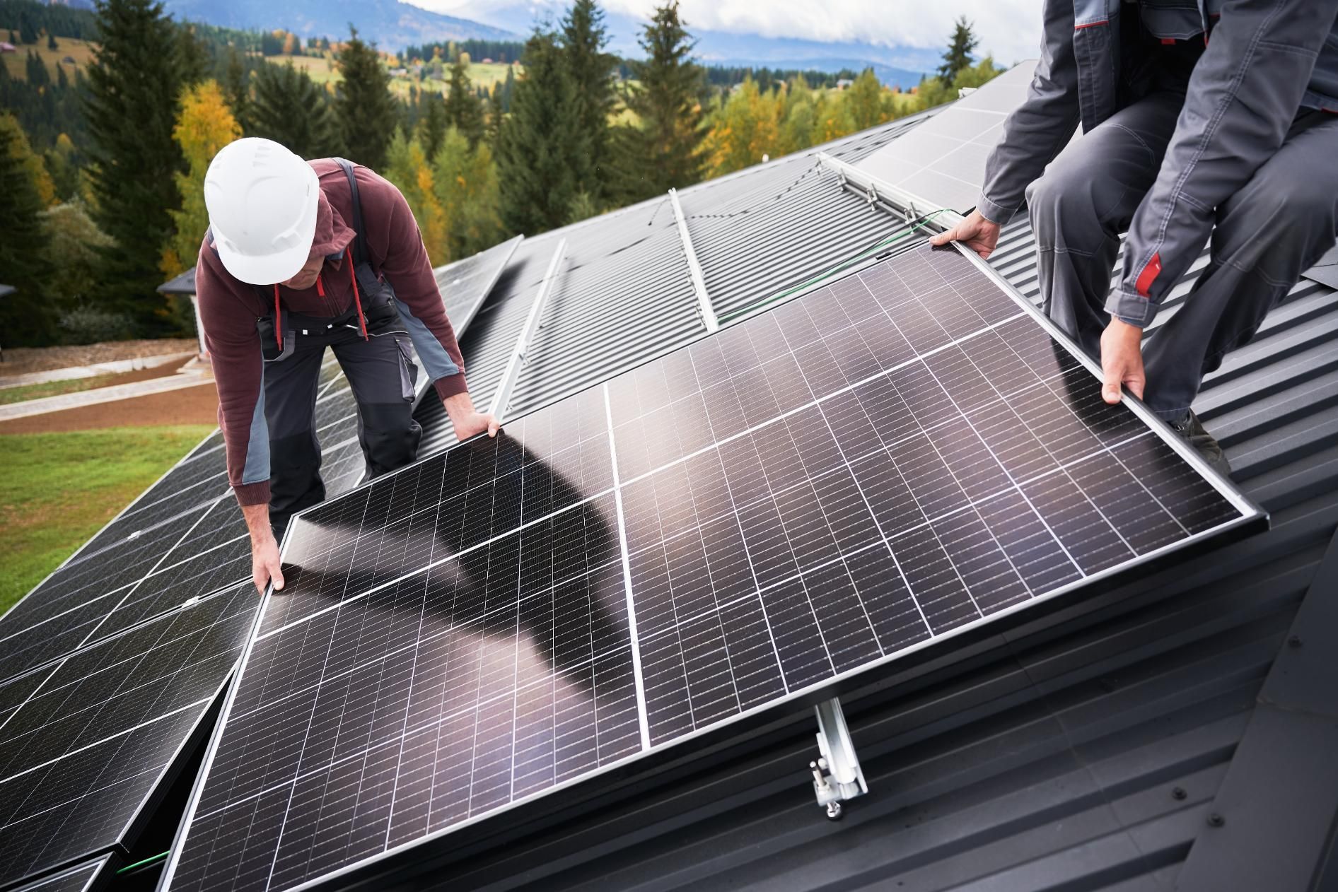 Two men are installing solar panels on the roof of a building.