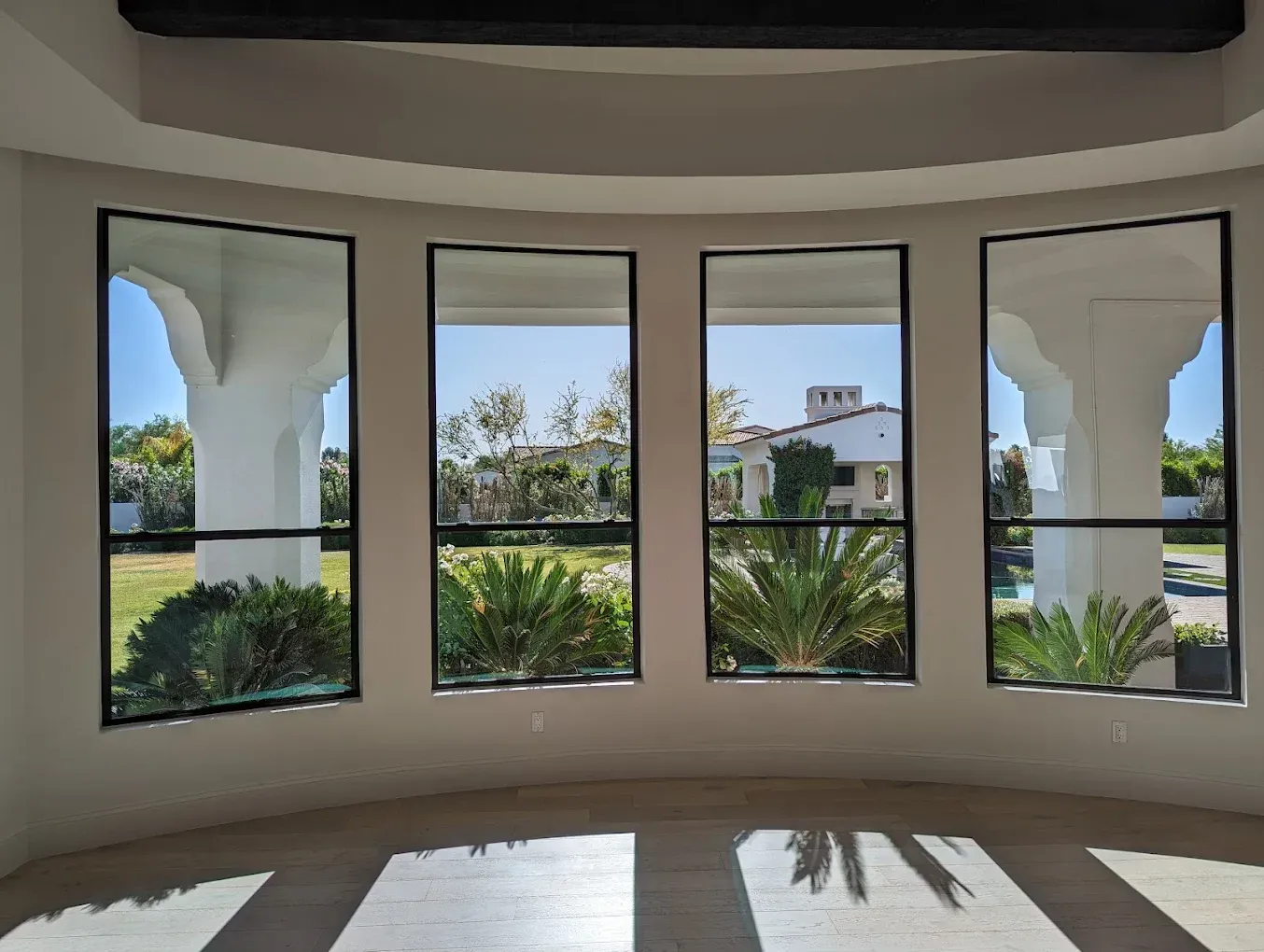 A room with a lot of windows and a view of a house.
