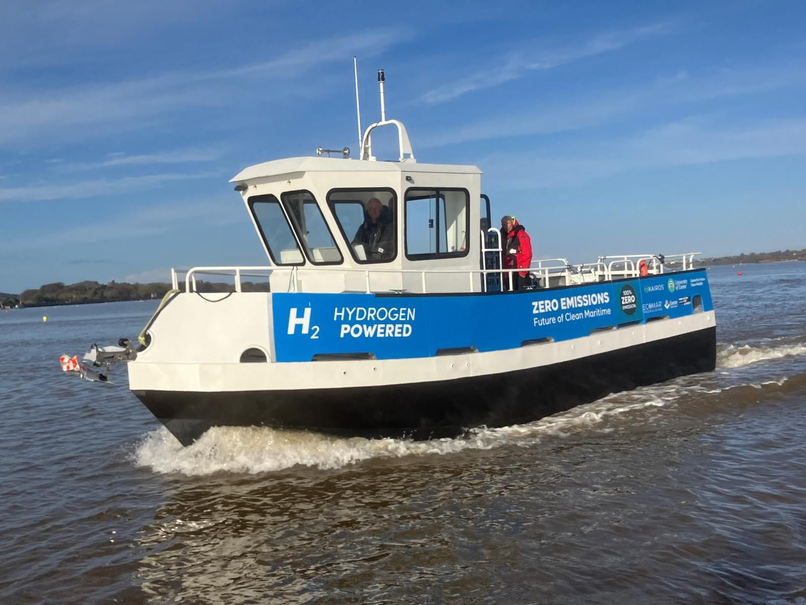 A blue and white boat is floating on top of a body of water.