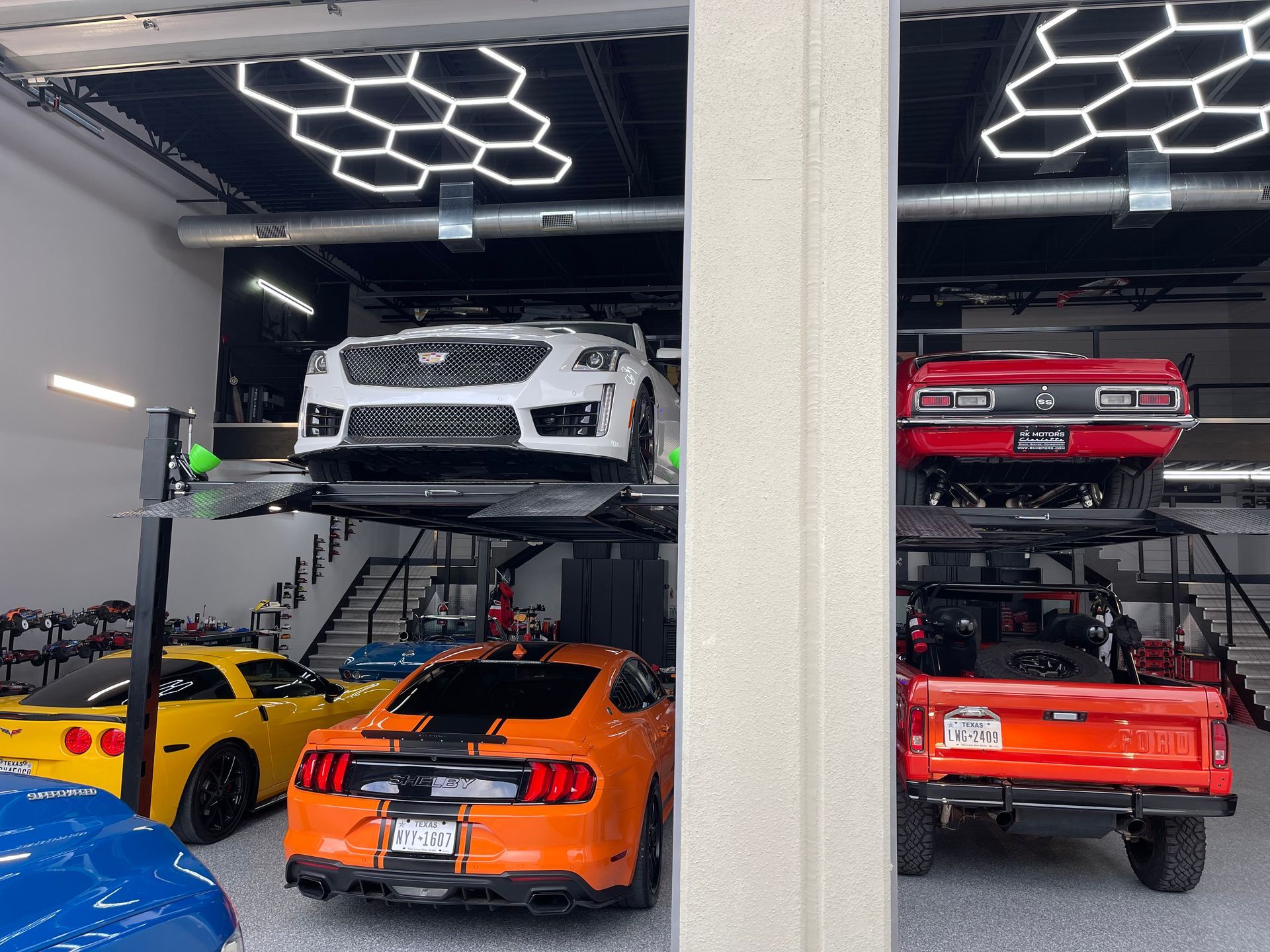 Multi-level car lift in a garage showcasing various colored cars.