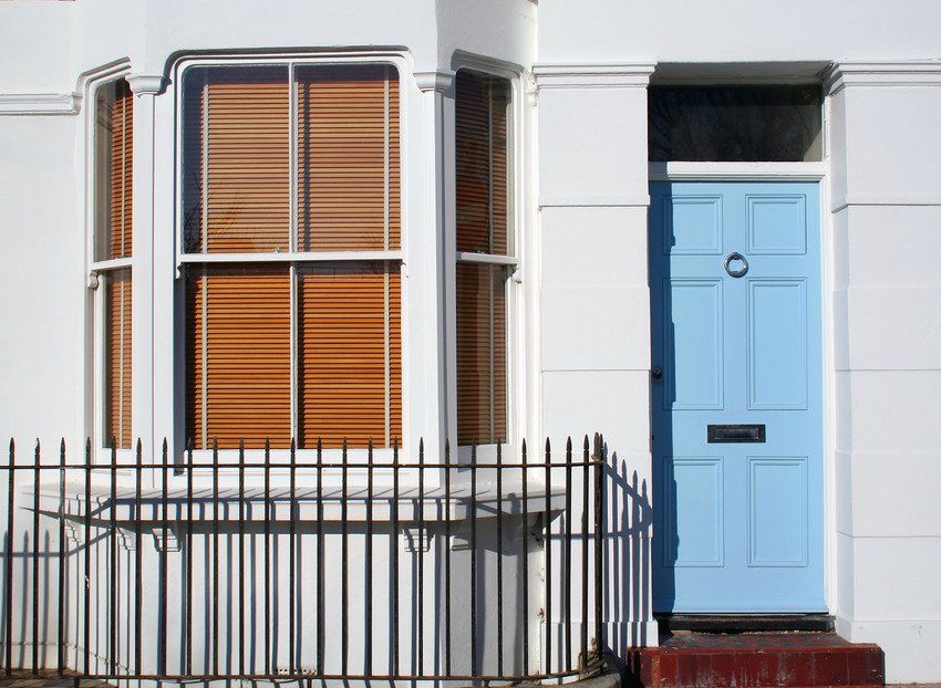 Wooden blinds and sky blue front door in the window (Brighton, England)