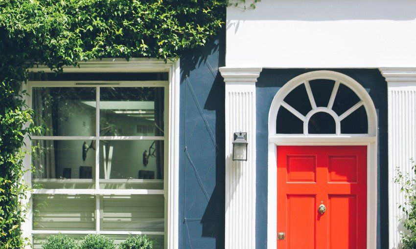 Front view of a red door and a window in a row house