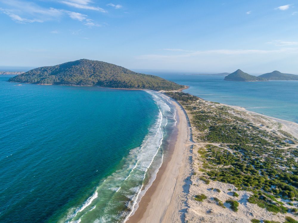 An Aerial View Of A Beach And Ocean With Mountains In The Background — Port Stephens Removals & Storage In Nelson Bay, NSW