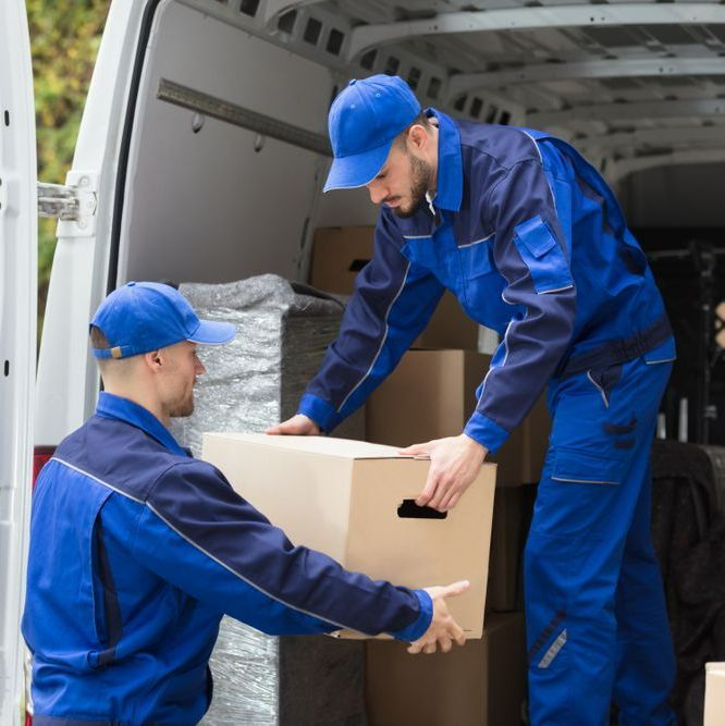 Two Men In Blue Uniforms Are Loading Boxes Into A Van — Port Stephens Removals & Storage In Salt Ash, NSW