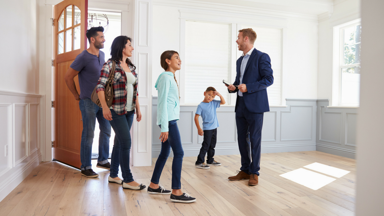 A Family Is Looking At A House With A Real Estate Agent — Port Stephens Removals & Storage In Salt Ash, NSW