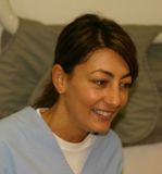 Una donna con una camicetta blu sorride alla telecamera