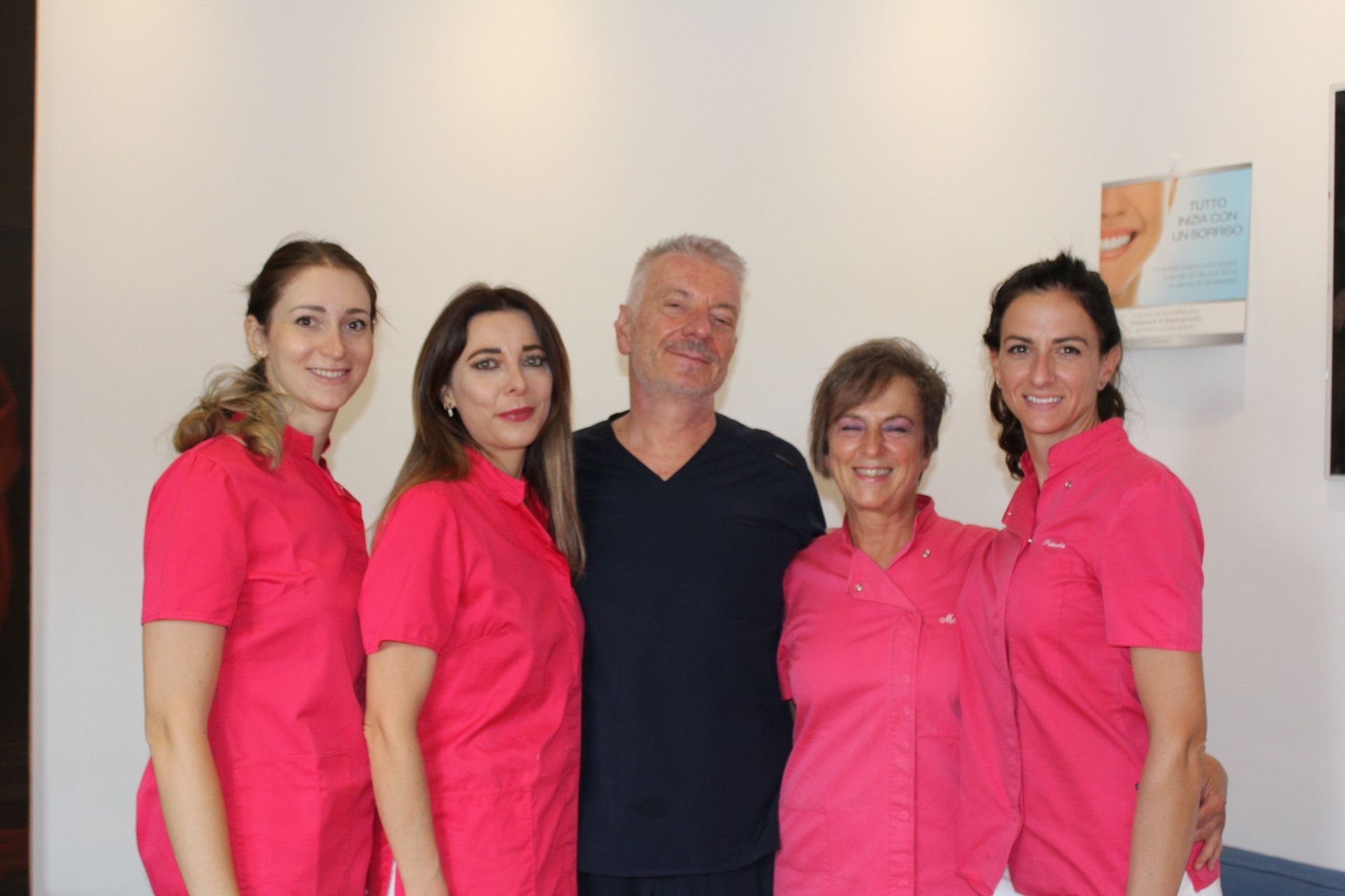 Un gruppo di persone in uniforme rosa posano per una foto.