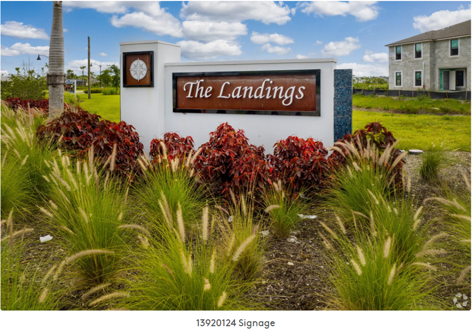 The Landings community entrance sign with landscaping and a house in the background