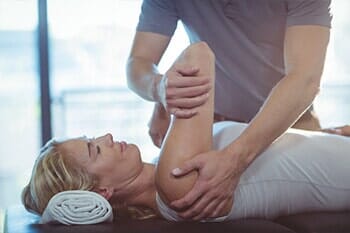 Woman receiving shoulder therapy from physiotherapist - Sports Therapy in Salina, KS