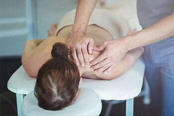 Physiotherapist giving neck massage to a woman - Sports Therapy in Salina, KS