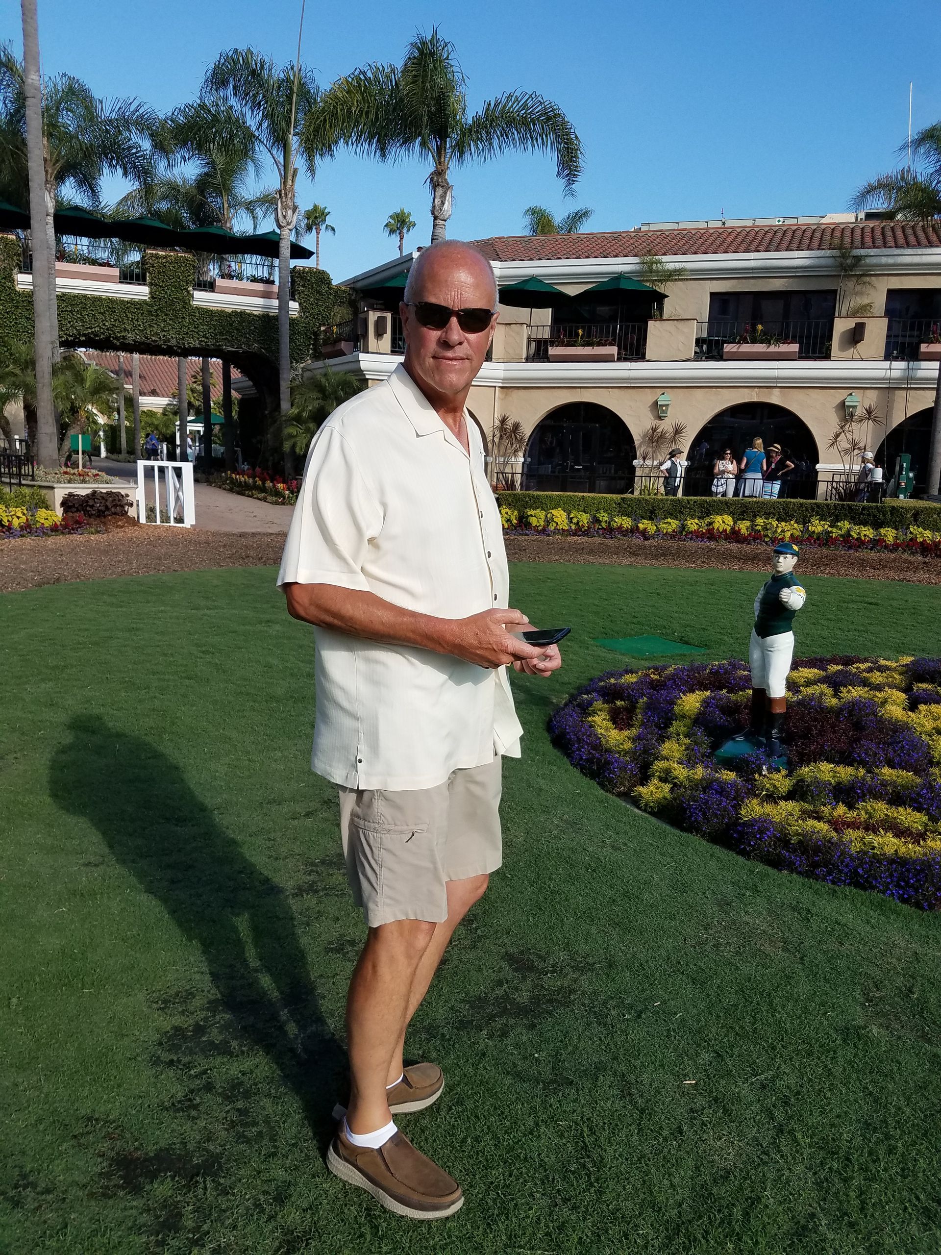 A man wearing sunglasses stands in front of a building
