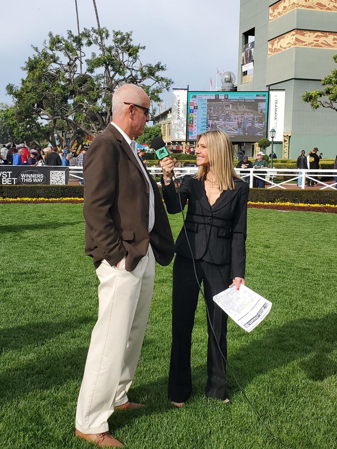 A woman is holding a microphone and talking to a man