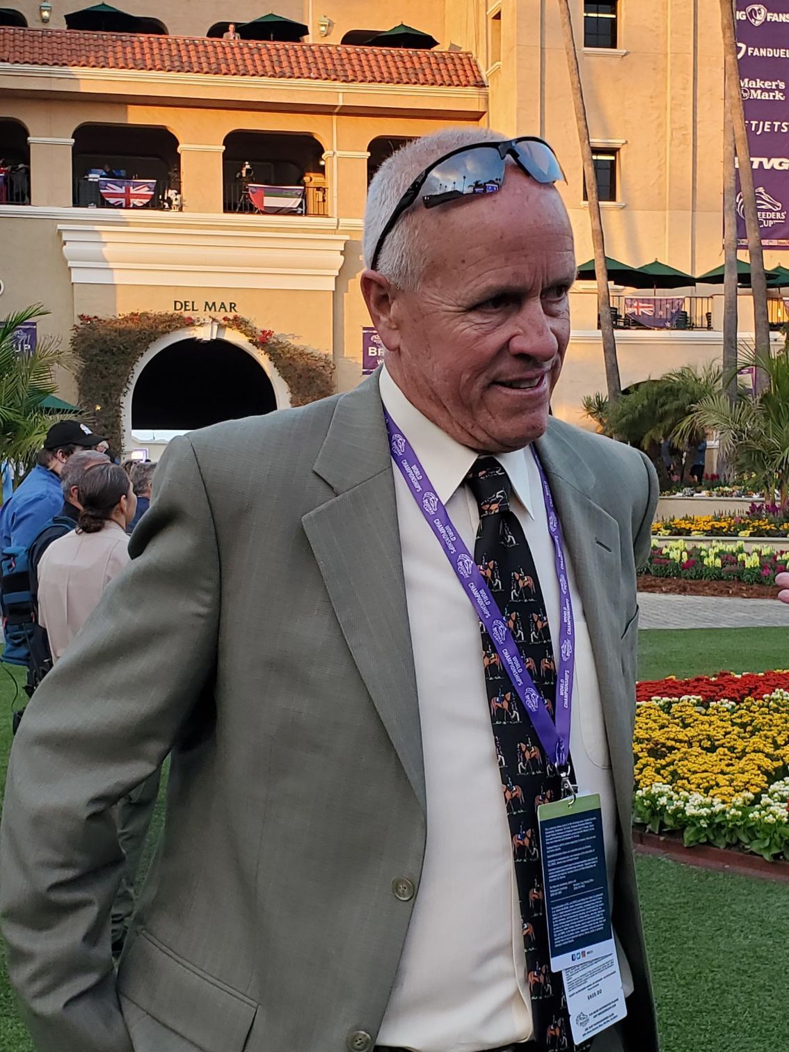 A man in a suit and tie with a lanyard around his neck