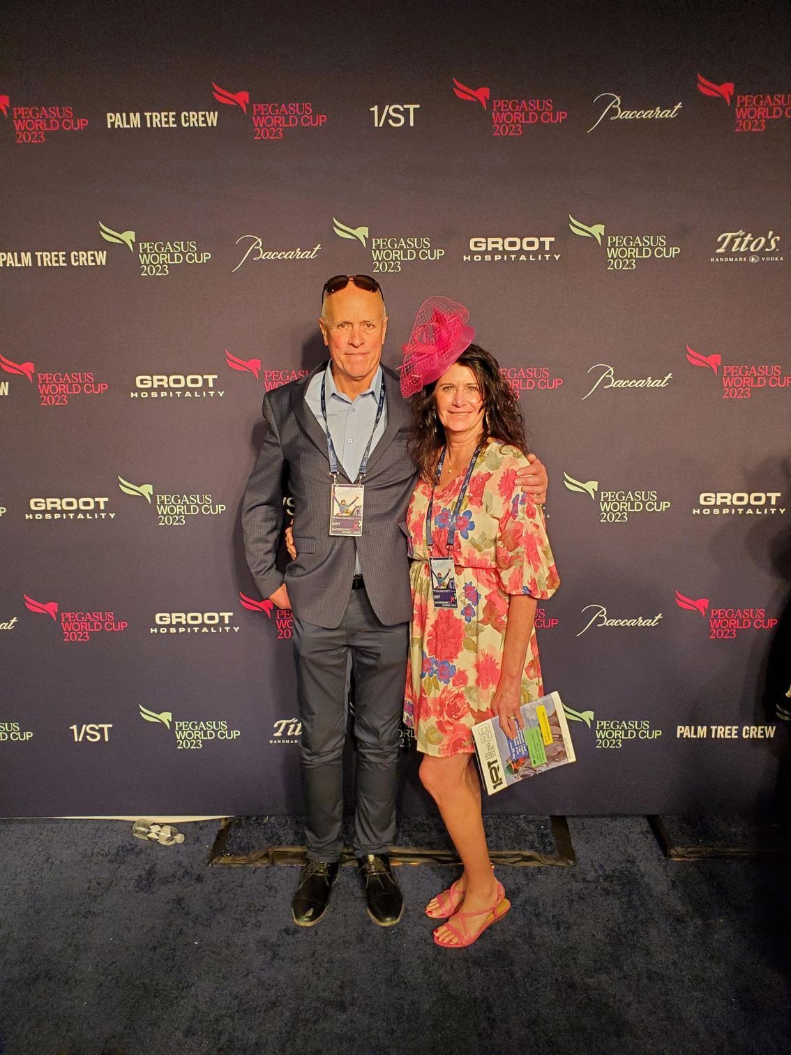 A man and a woman are posing for a picture on a red carpet.