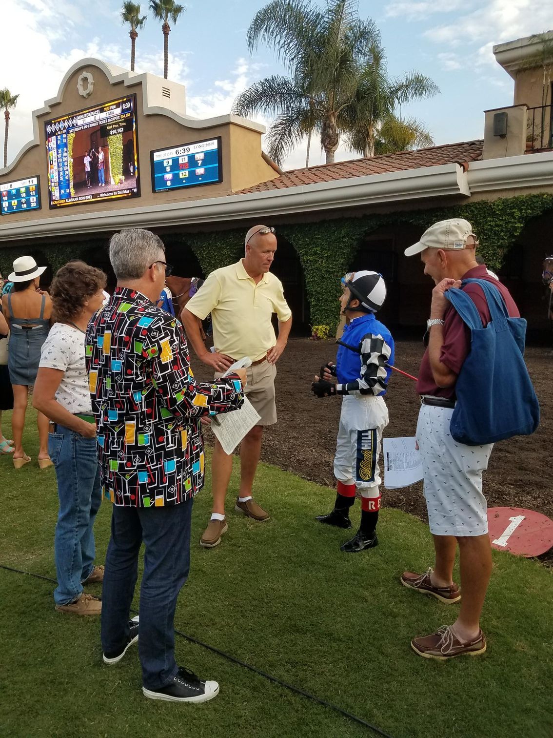 A group of people standing in front of a building with the number 1 on it